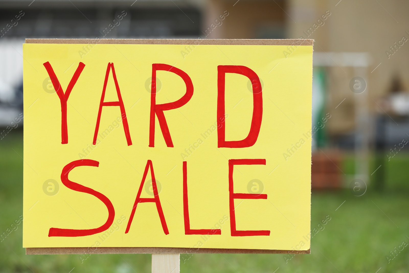 Photo of Sign Yard sale written on yellow paper outdoors, closeup