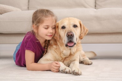 Photo of Young girl with her adorable dog on floor at home