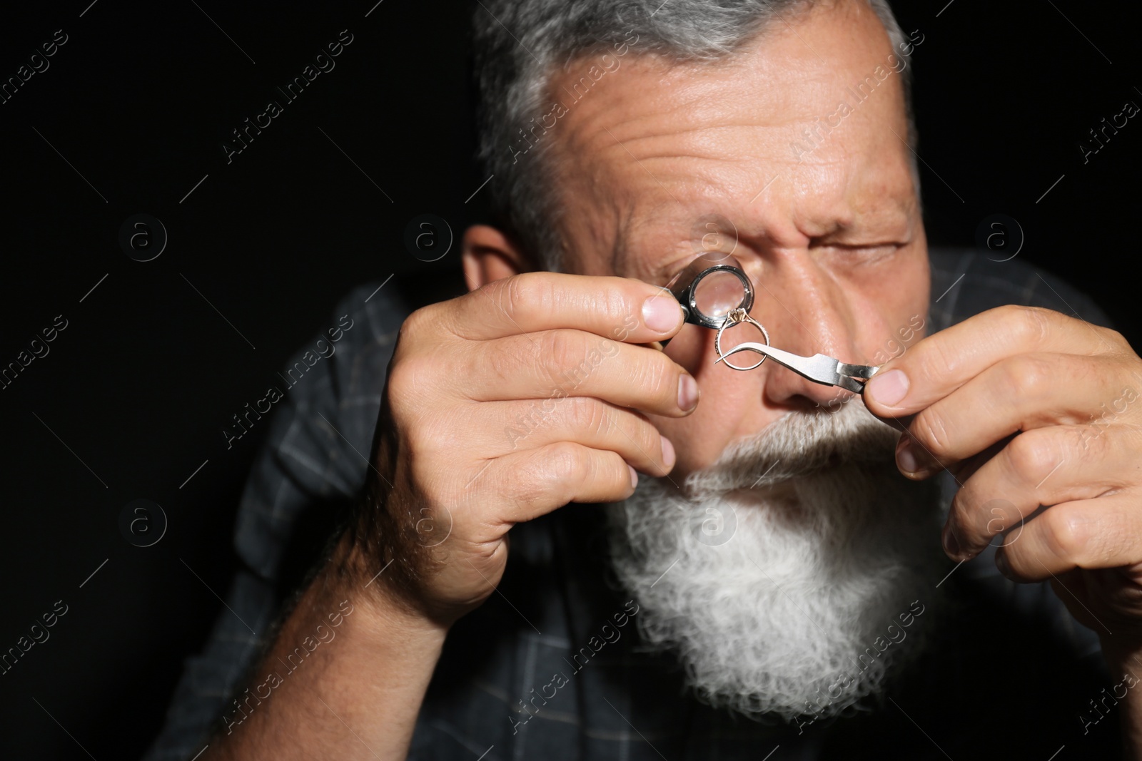 Photo of Male jeweler evaluating diamond ring in workshop