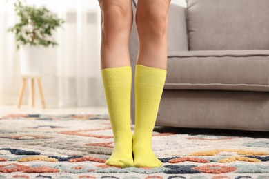 Photo of Woman in stylish yellow socks indoors, closeup