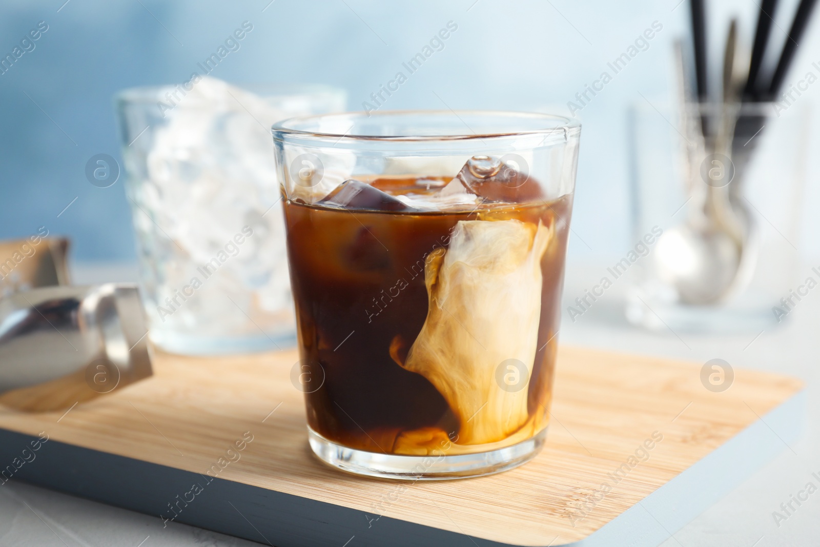 Photo of Glass with cold brew coffee and milk on table