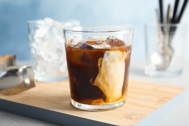 Glass with cold brew coffee and milk on table