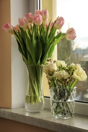 Beautiful bouquets in vases on windowsill indoors. Spring time