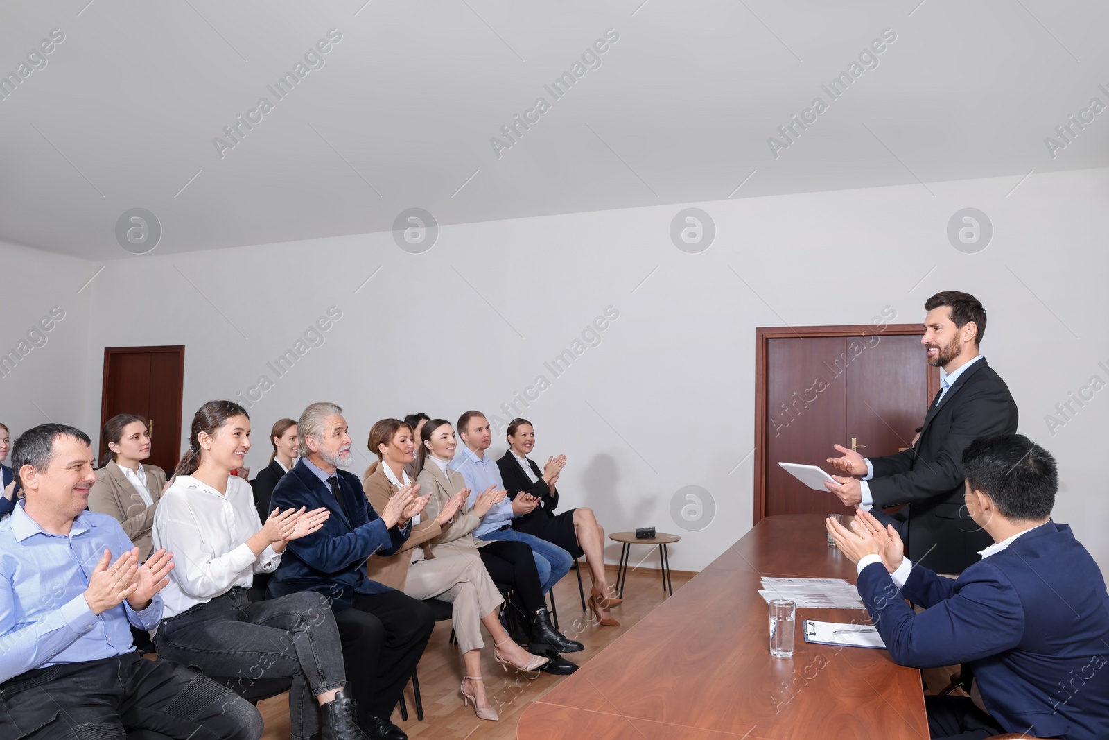 Photo of Business conference. People in meeting room listening to speaker report