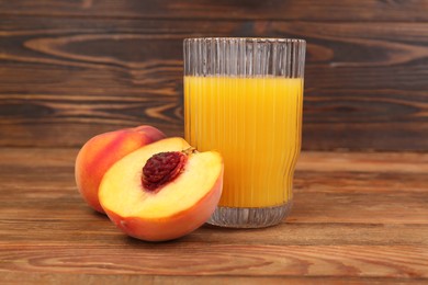 Glass of delicious peach juice and fresh fruits on wooden table