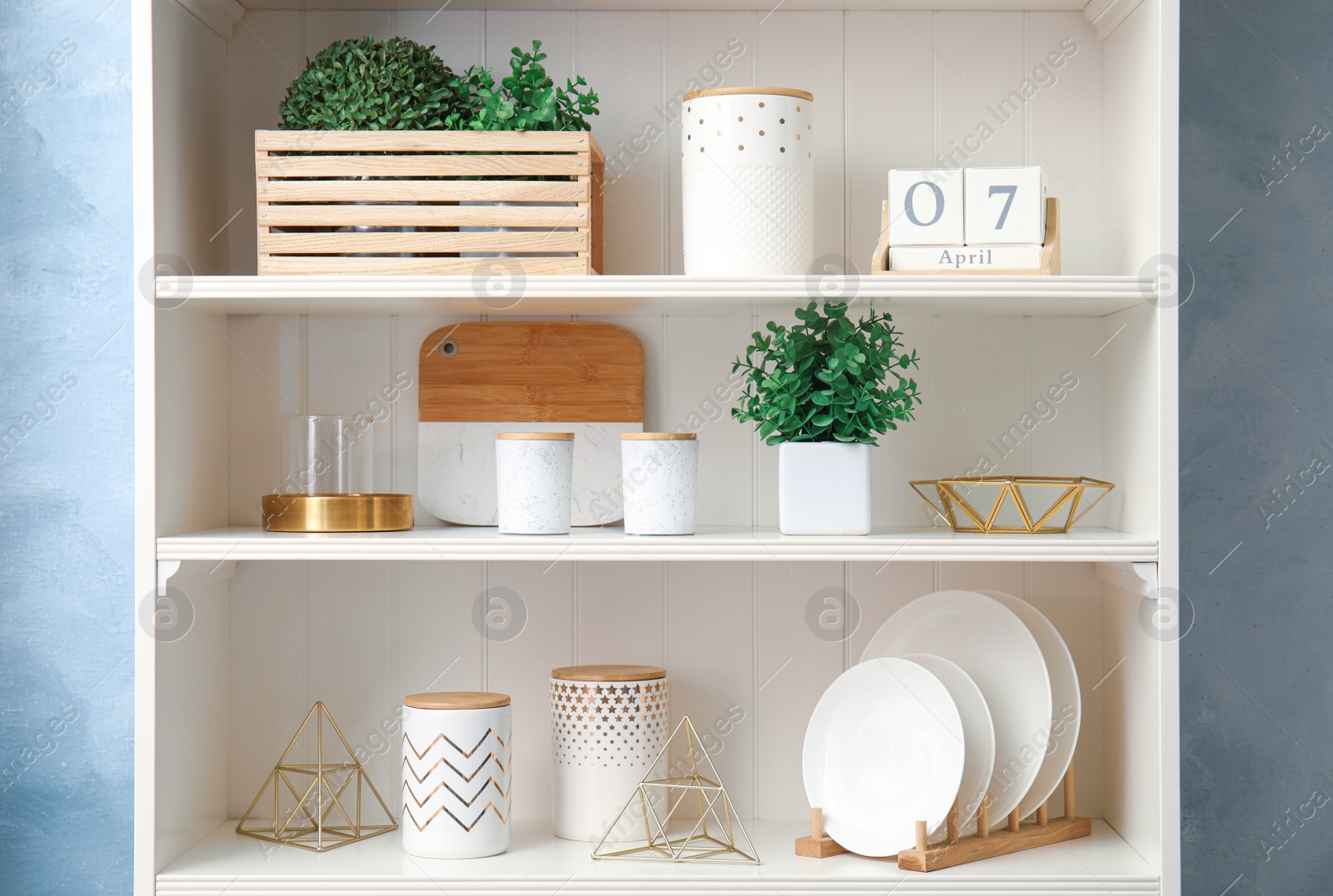Photo of White shelving unit with dishes and different decorative stuff