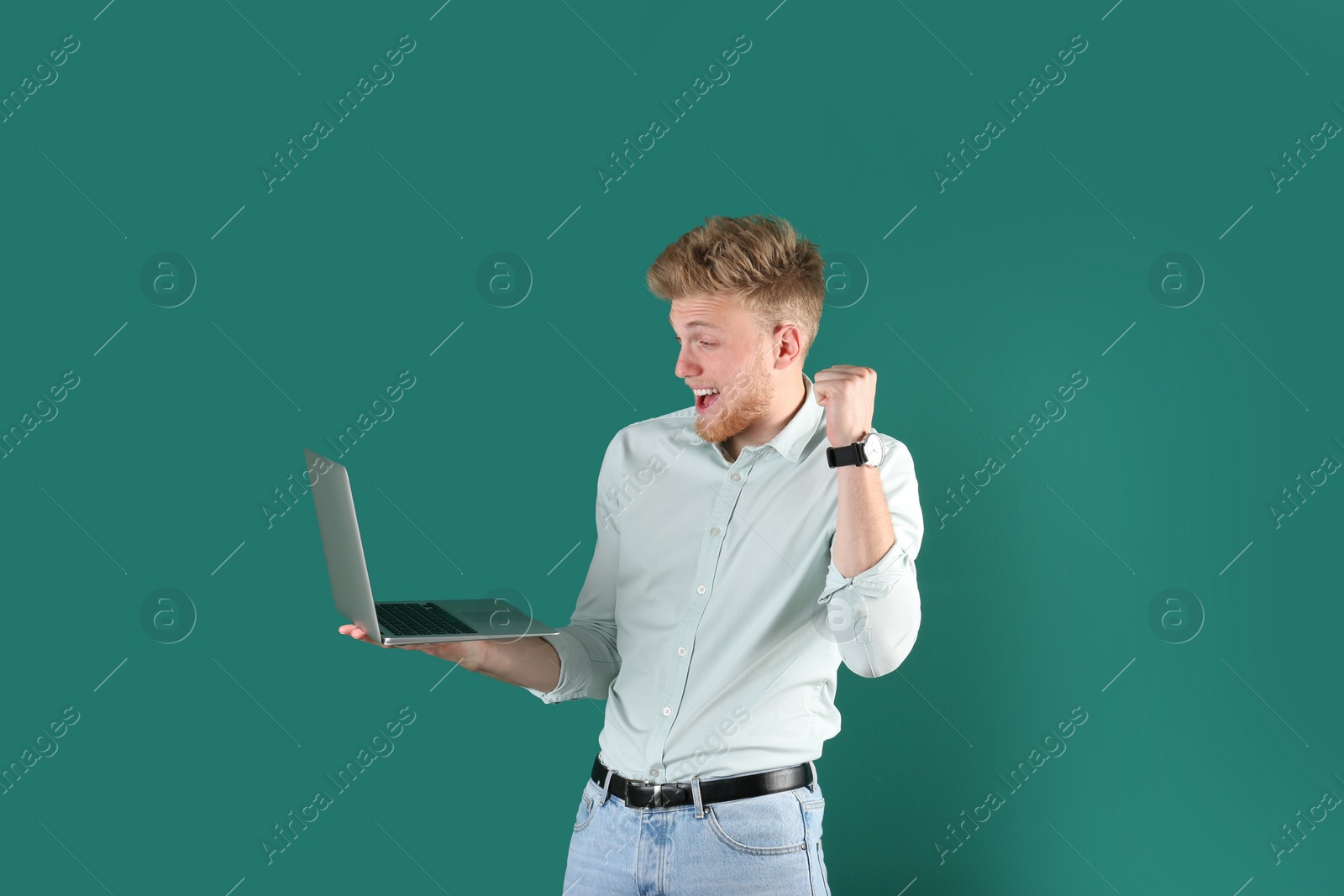 Photo of Emotional man with laptop on green background