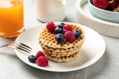 Photo of Tasty breakfast with wafers served on light grey marble table