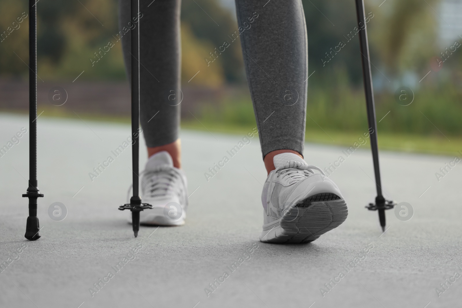 Photo of Woman performing Nordic walking outdoors, closeup view