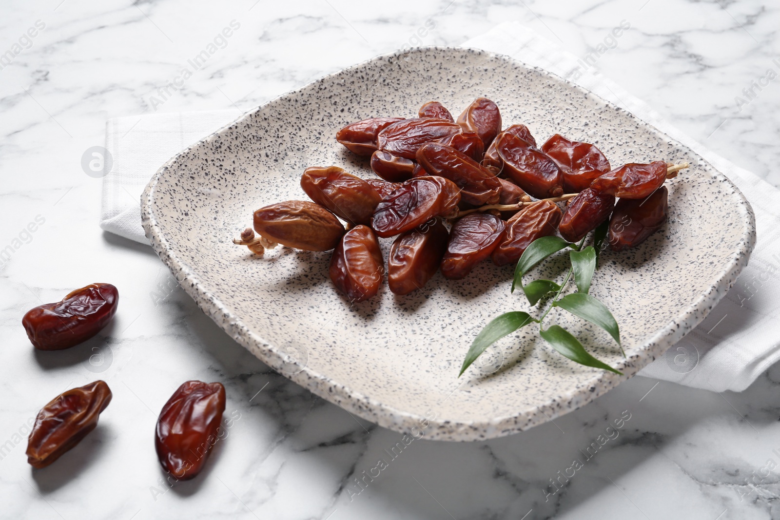 Photo of Tasty sweet dried dates on white marble table
