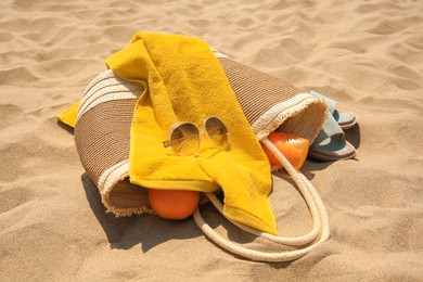 Photo of Beach bag, sunglasses and other accessories on sand