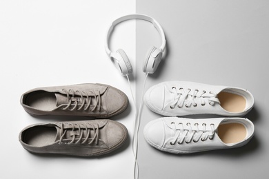 Photo of Flat lay composition with different sneakers and headphones on color background