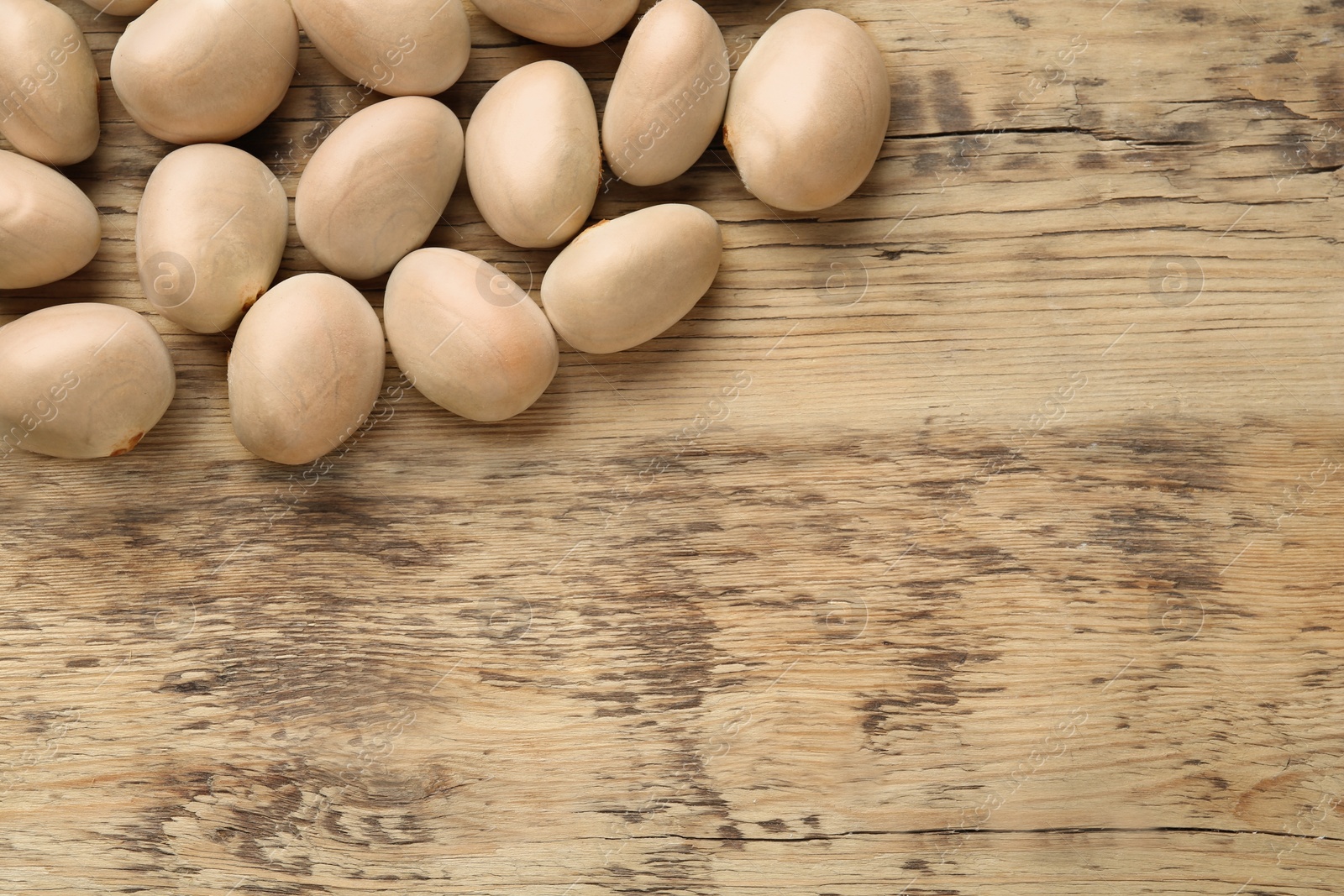 Photo of Raw jackfruit seeds on wooden table, flat lay. Space for text