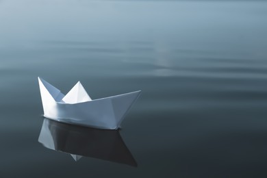Photo of White paper boat floating on river, space for text