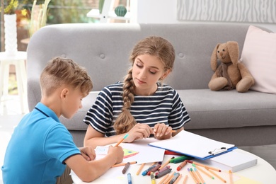 Photo of Young female psychologist working with little child in office