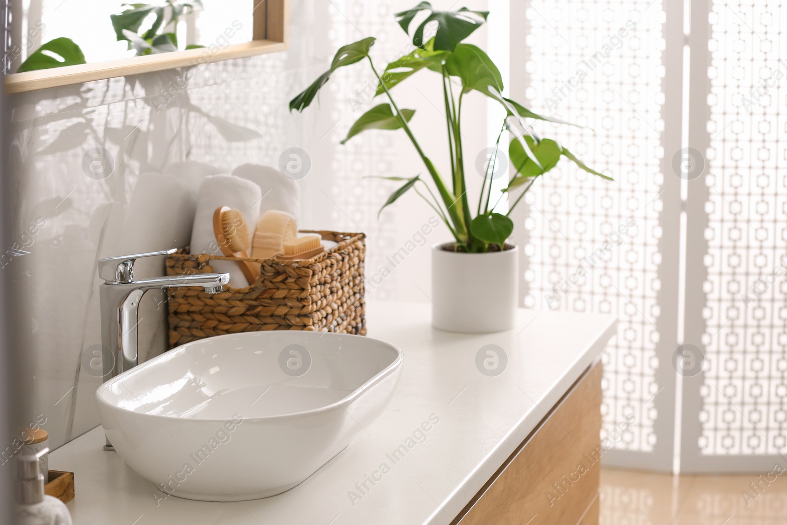 Photo of Stylish vessel sink on light countertop in modern bathroom