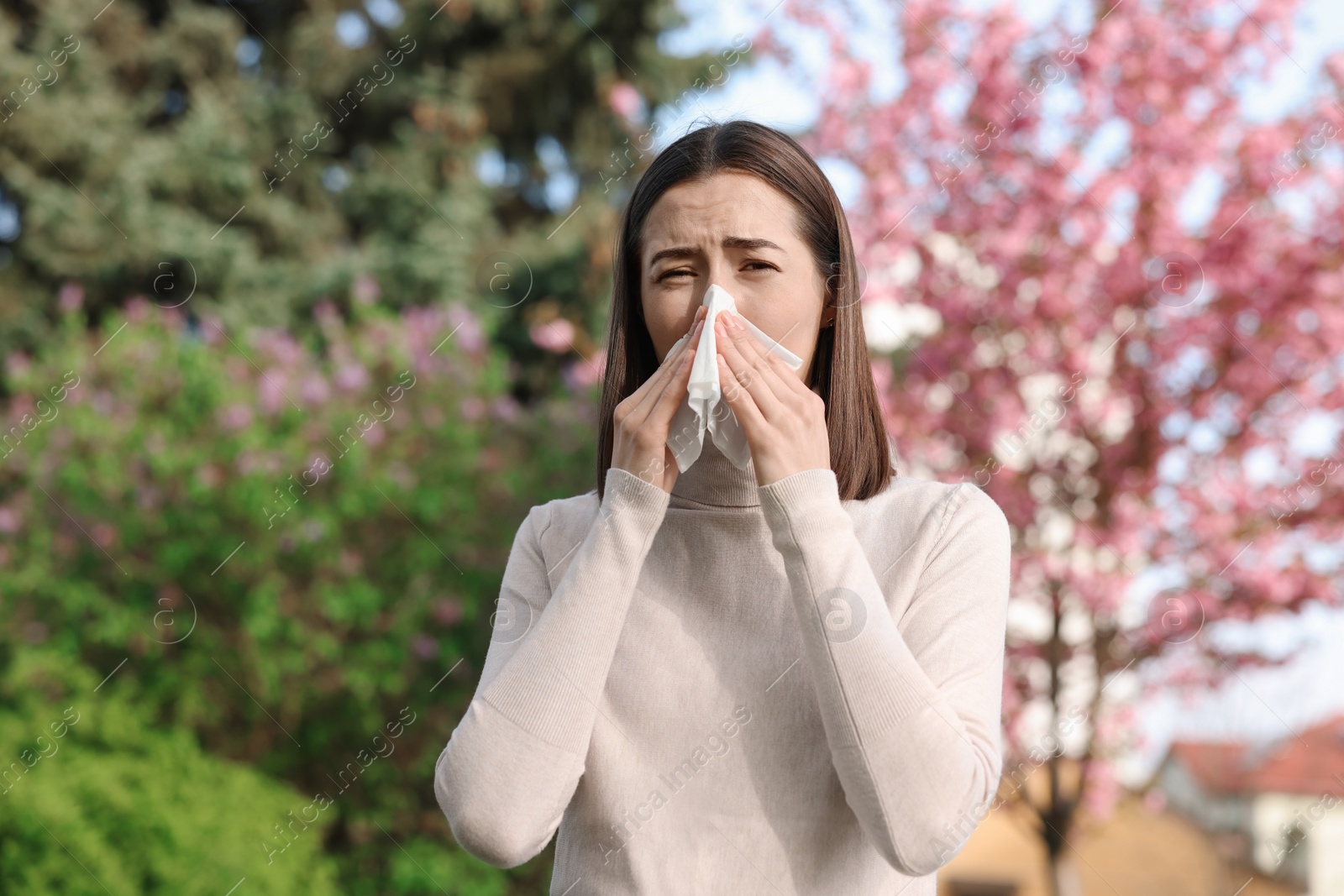 Photo of Woman with napkin suffering from seasonal allergy on spring day