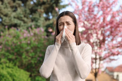 Photo of Woman with napkin suffering from seasonal allergy on spring day