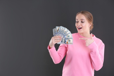 Photo of Portrait of emotional young woman with money on grey background. Space for text