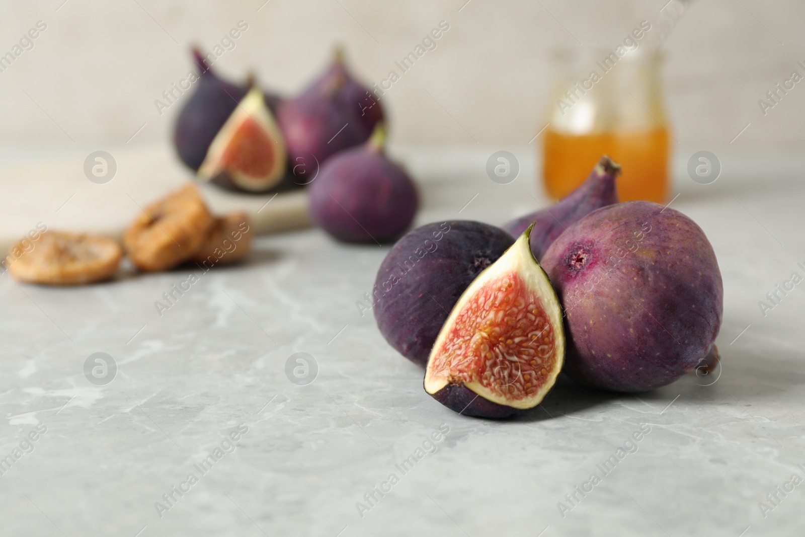 Photo of Tasty raw figs on light grey marble table, closeup