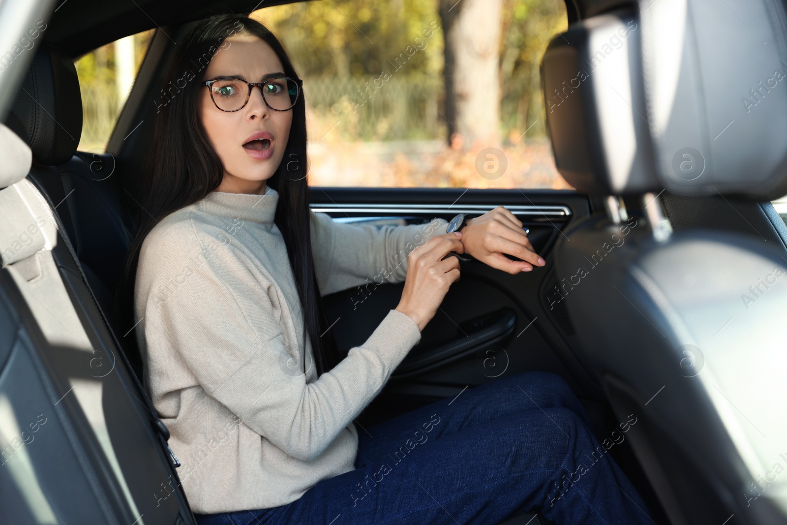 Photo of Emotional woman checking time on watch in car. Being late concept