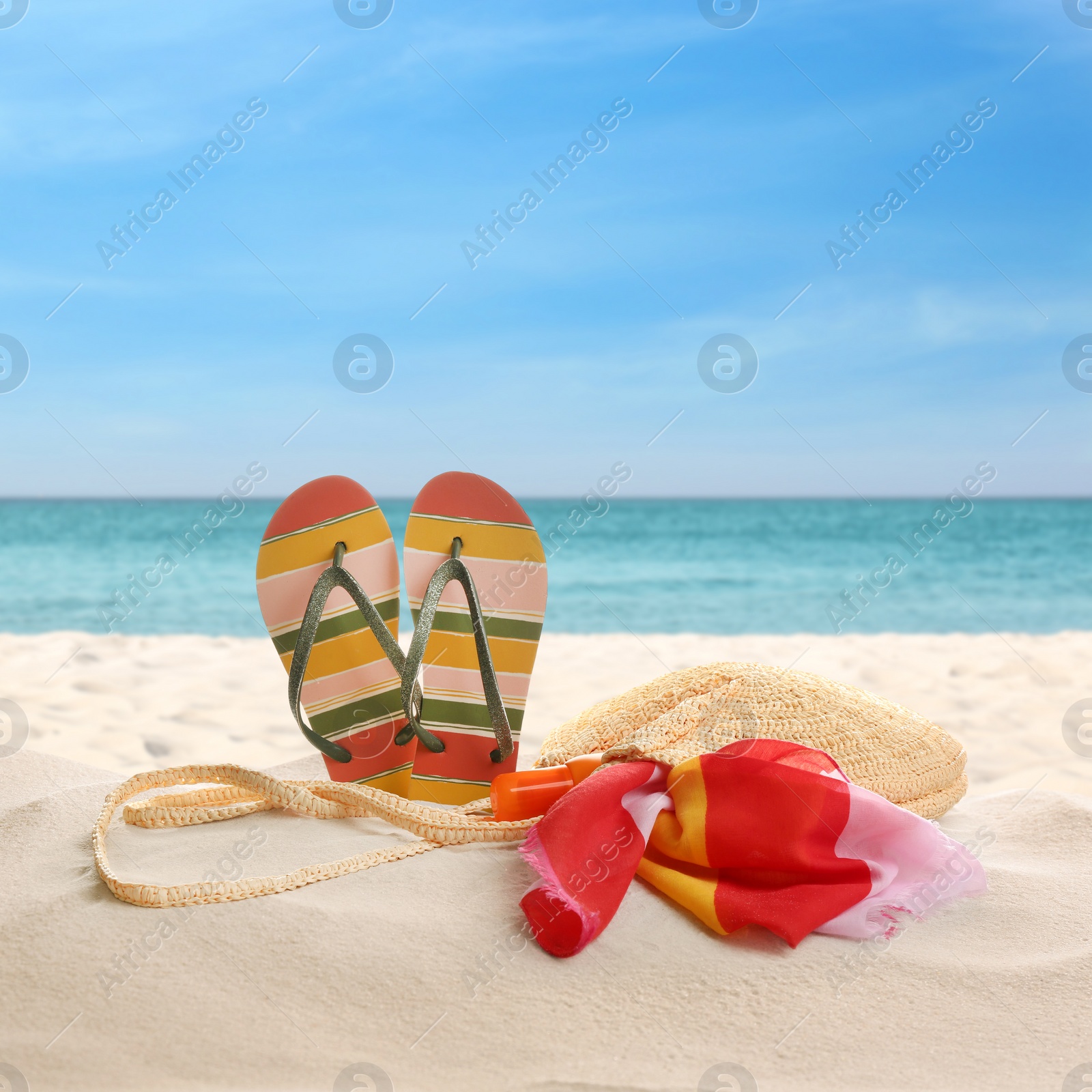 Image of Bag with accessories on sunny ocean beach. Summer vacation