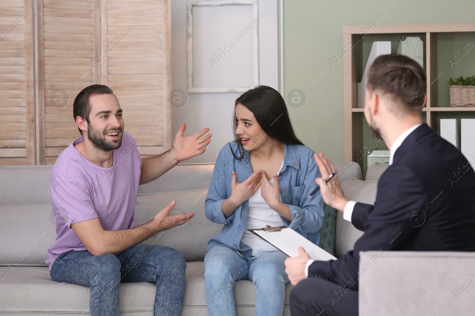 Photo of Family psychologist working with young couple in office