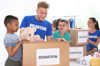 Volunteers with children sorting donation goods indoors