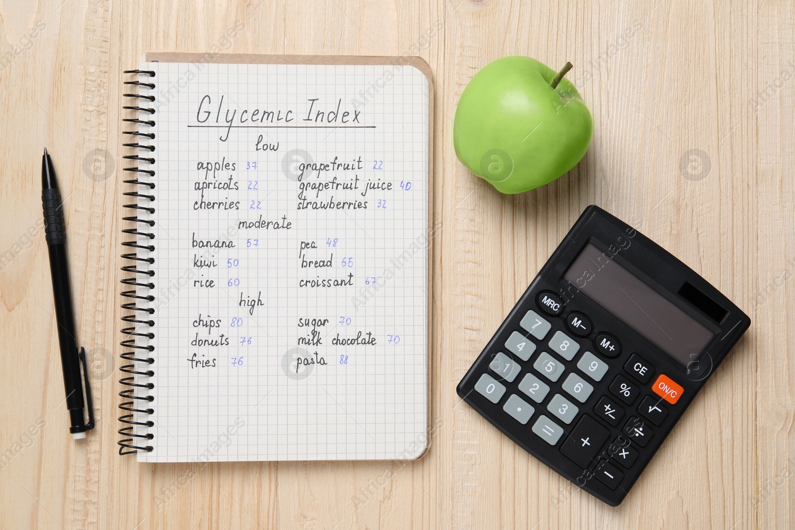 Photo of Notebook with products of low, moderate and high glycemic index, pen, calculator and apple on wooden table, flat lay