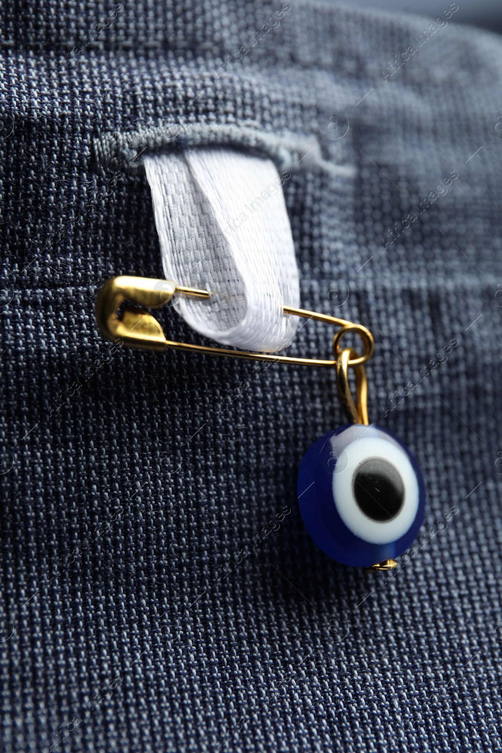 Photo of Evil eye safety pin on clothing, closeup