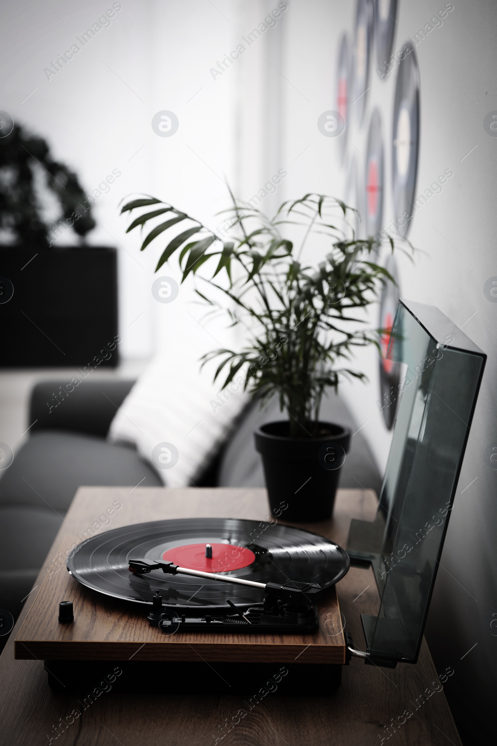 Image of Stylish turntable with vinyl disc in living room