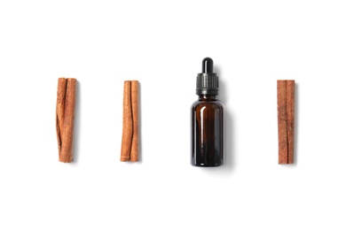 Photo of Flat lay composition with cinnamon essential oil on white background