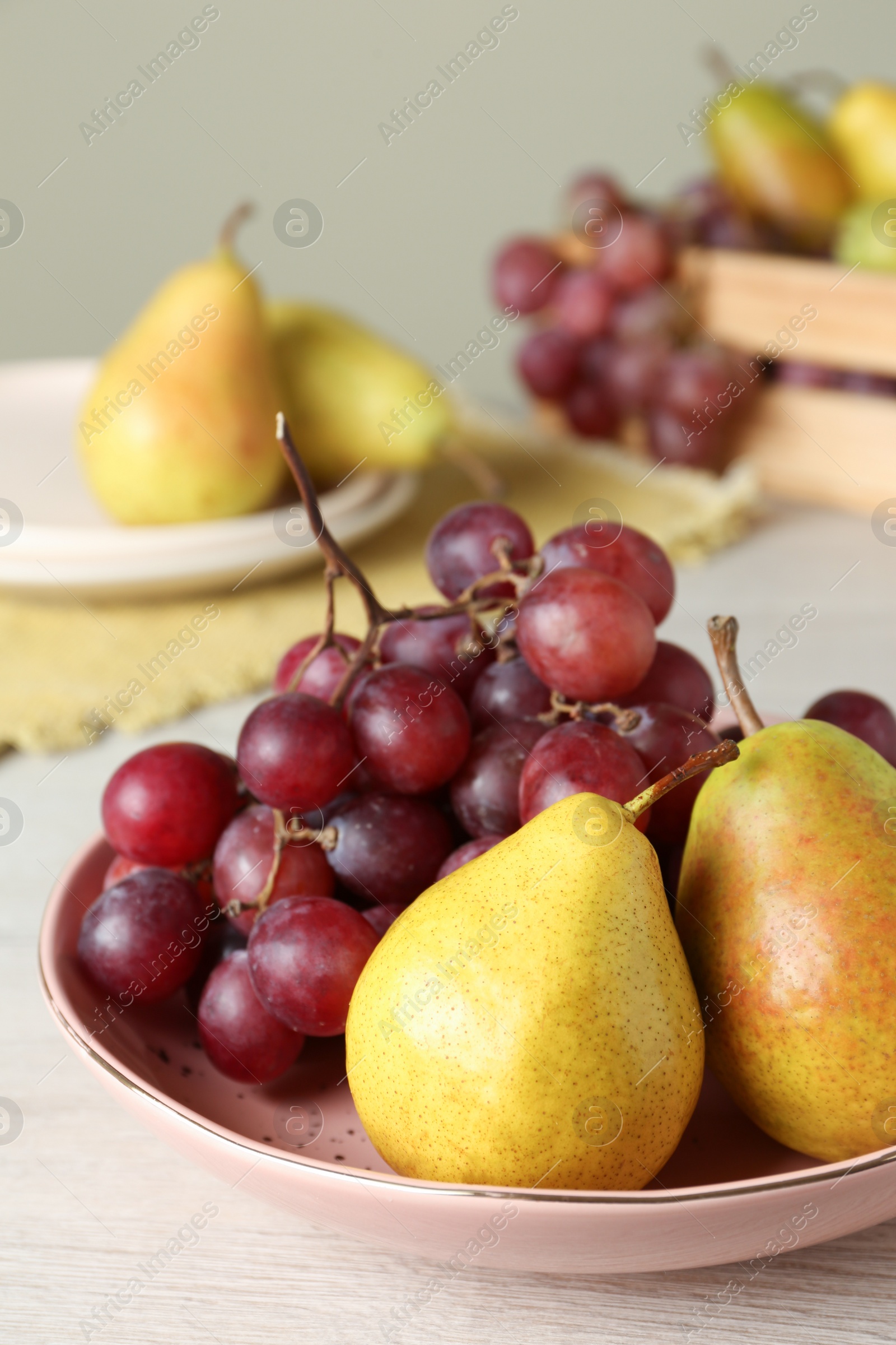 Photo of Fresh ripe grapes and pears on white wooden table