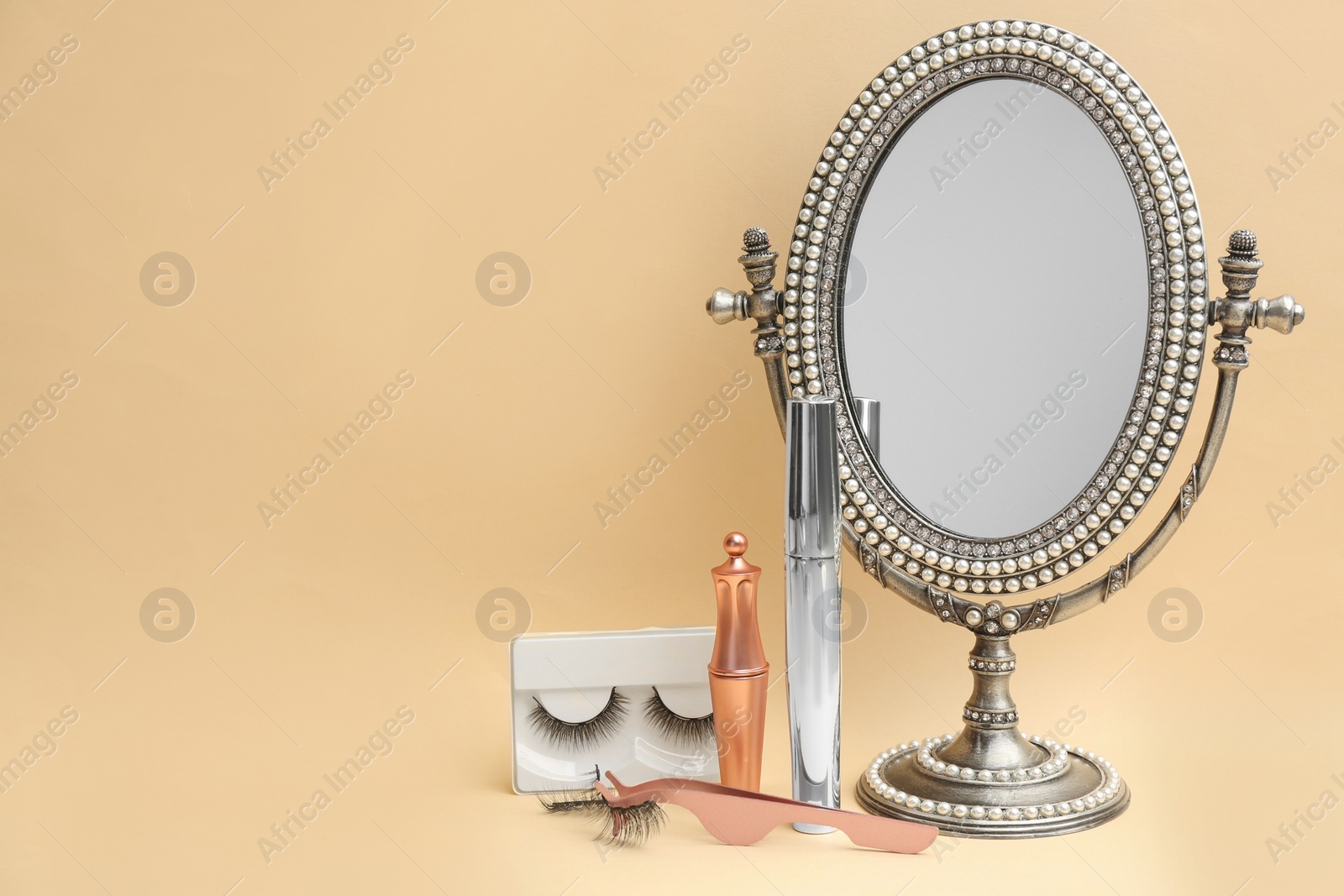 Photo of Magnetic eyelashes and accessories on beige background. Space for text