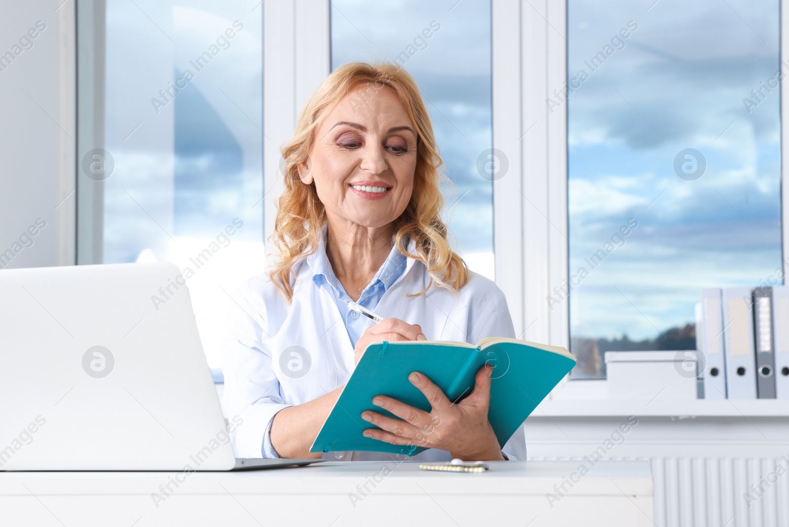 Photo of Doctor with laptop consulting patient in clinic. Online medicine concept