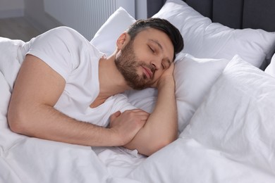 Photo of Handsome man sleeping in soft bed at home