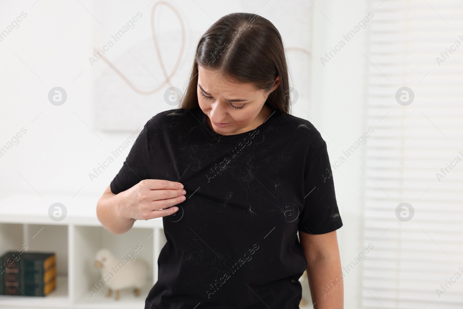 Photo of Woman with pet hair on her black clothers at home