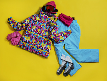 Stylish winter sport clothes on yellow background, flat lay