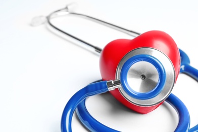Photo of Stethoscope and heart model on light background, closeup. Medical equipment