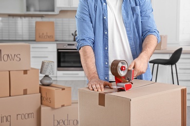 Photo of Man packing moving box indoors, closeup. Space for text