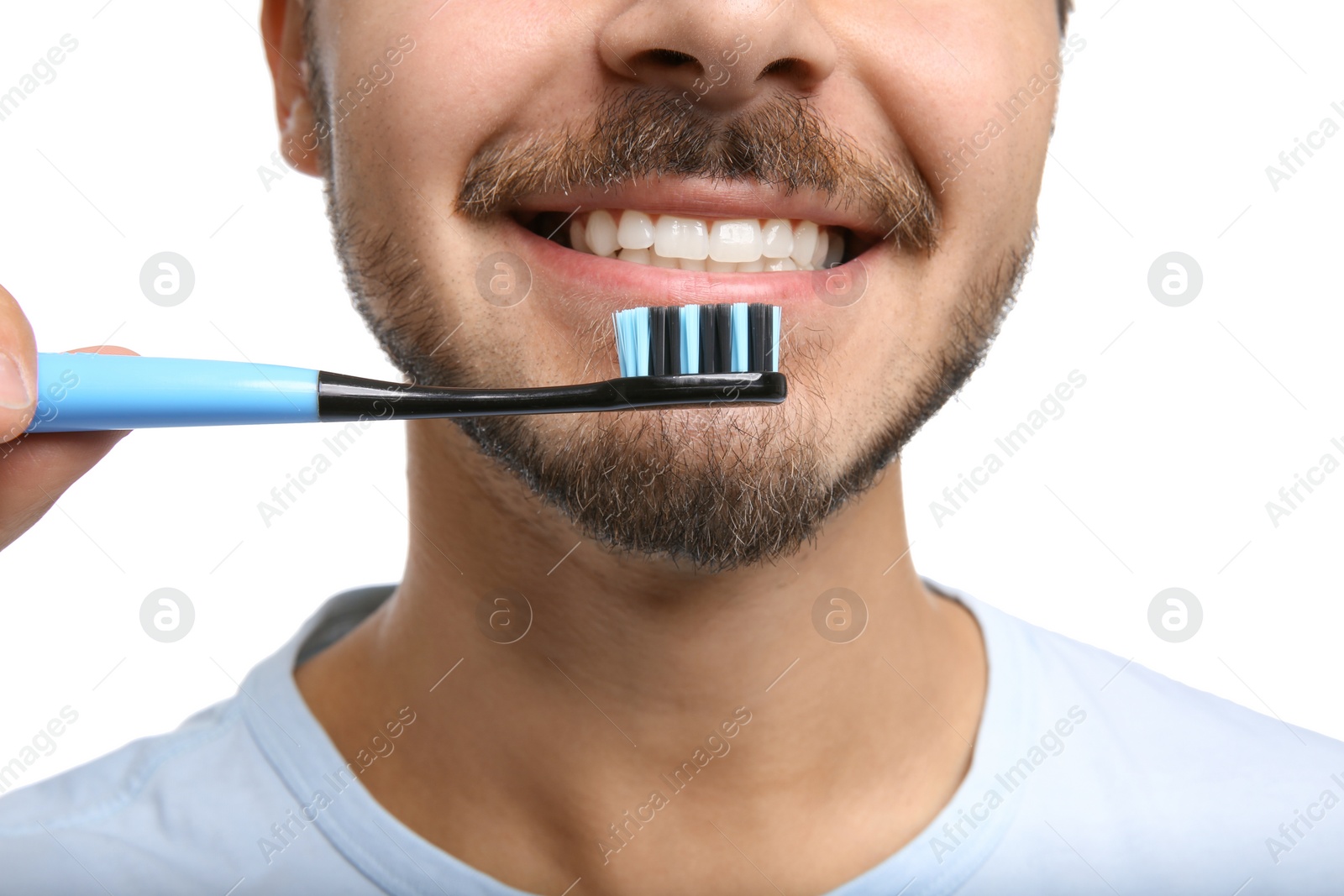 Photo of Young man with toothbrush on white background, closeup