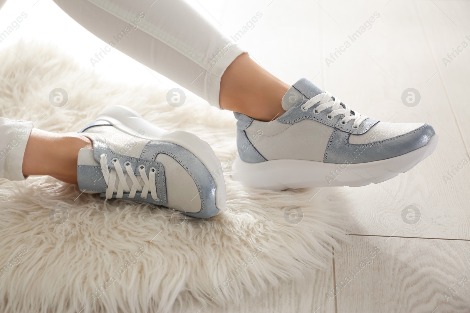 Photo of Woman wearing comfortable stylish sneakers indoors, closeup