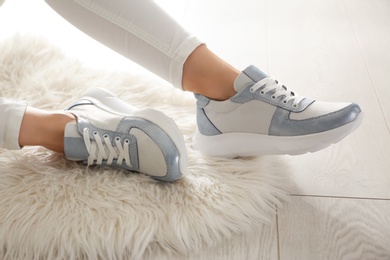 Photo of Woman wearing comfortable stylish sneakers indoors, closeup