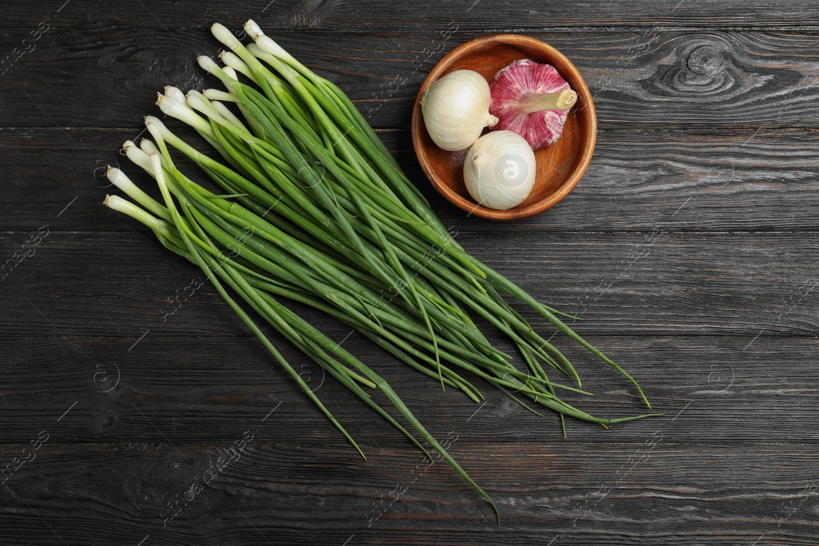 Photo of Flat lay composition of onions and garlic on dark wooden table