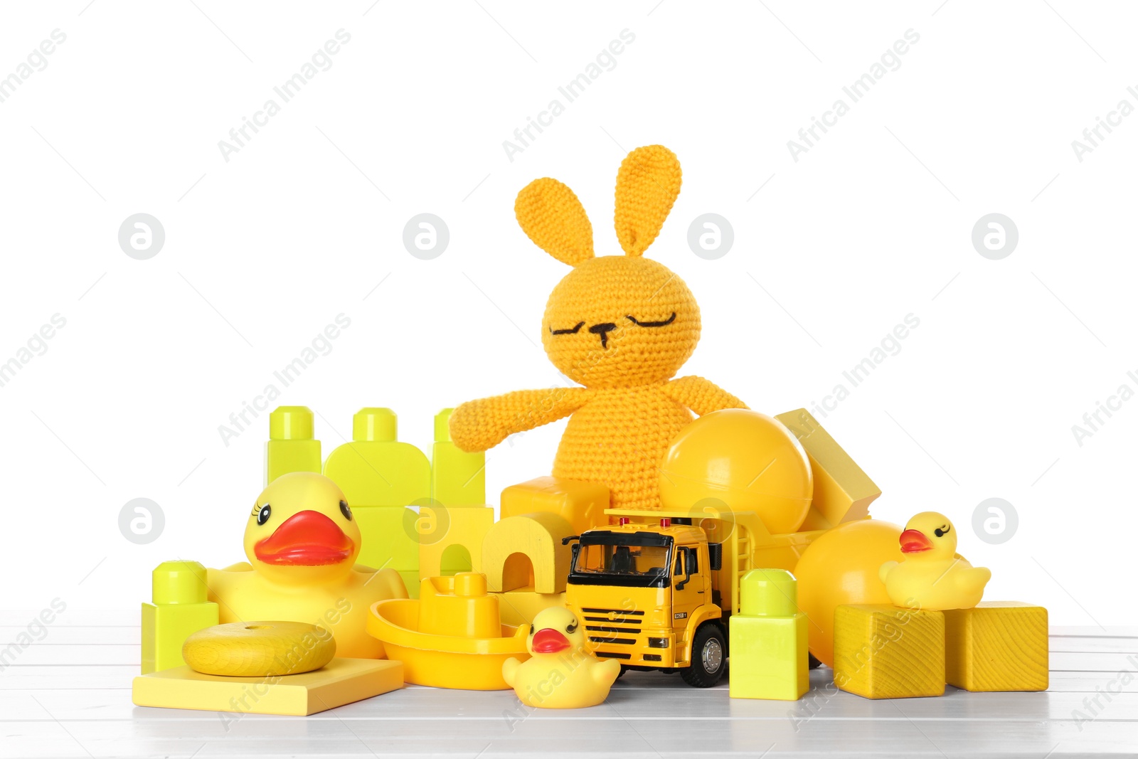 Photo of Different children's toys on pink wooden table against white background