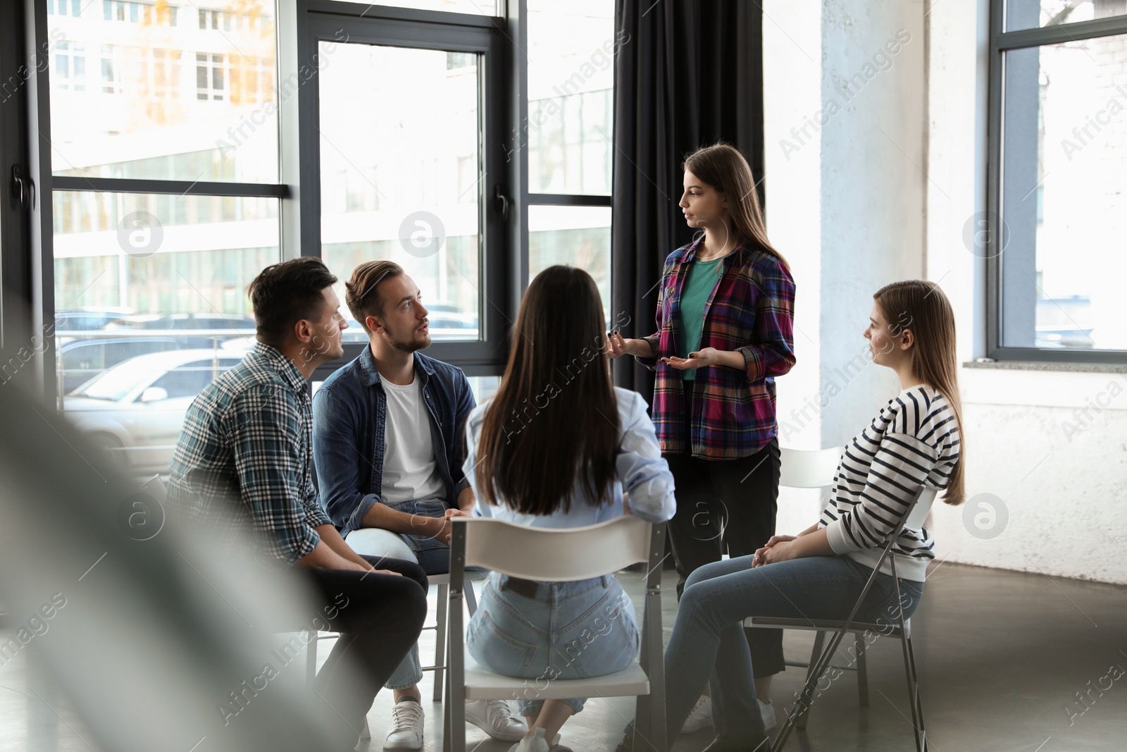 Photo of Psychotherapist working with patients in group therapy session indoors