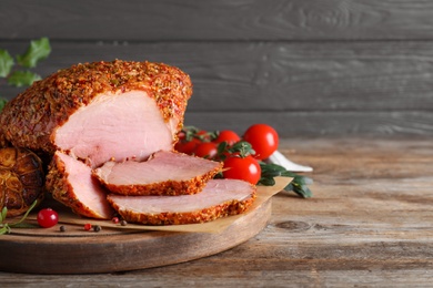 Homemade delicious ham on wooden table, space for text. Festive dinner