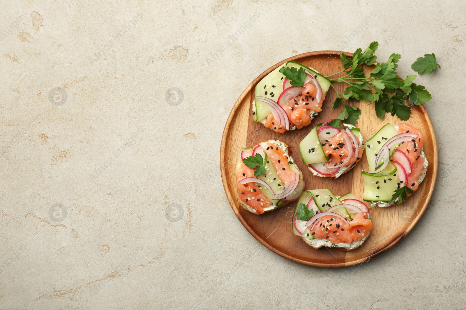 Photo of Tasty canapes with salmon served on light grey table, top view. Space for text