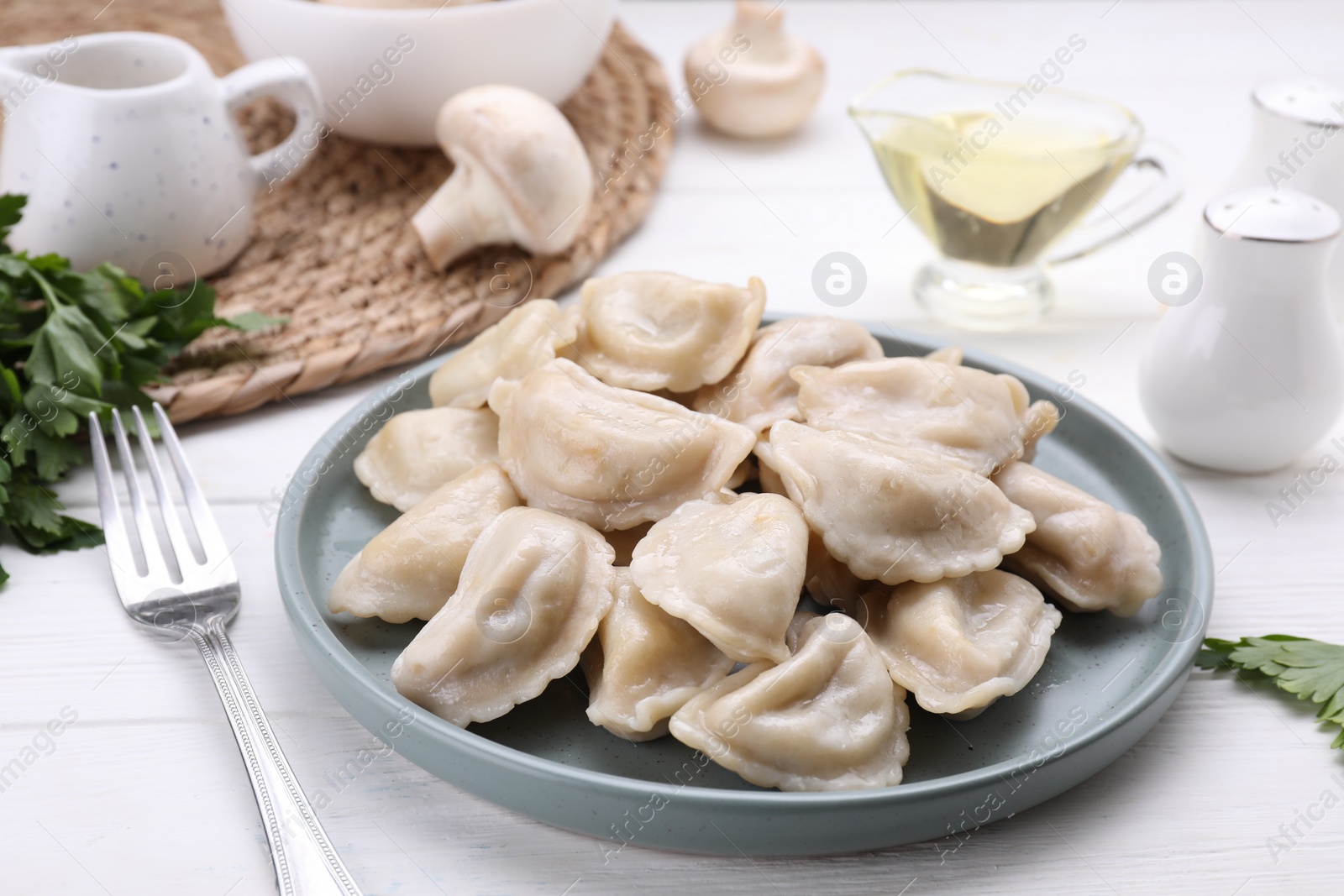 Photo of Delicious dumplings (varenyky) with potatoes served on white wooden table