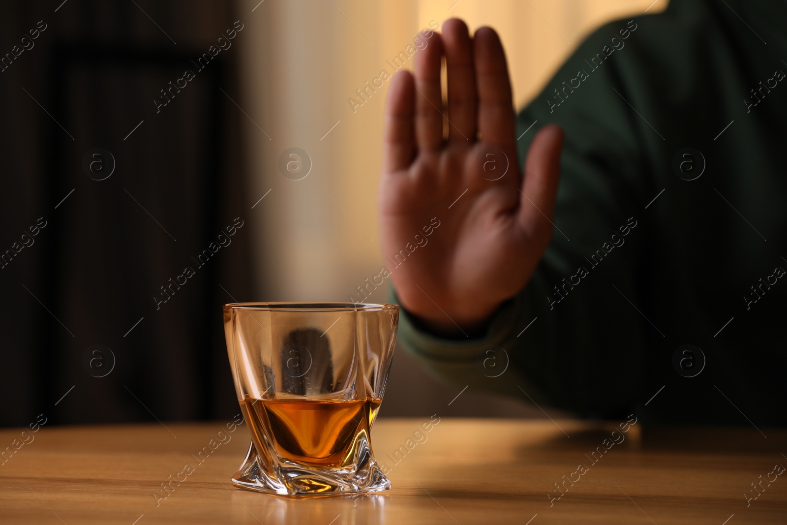 Photo of Man refusing to drink whiskey indoors, closeup. Alcohol addiction treatment